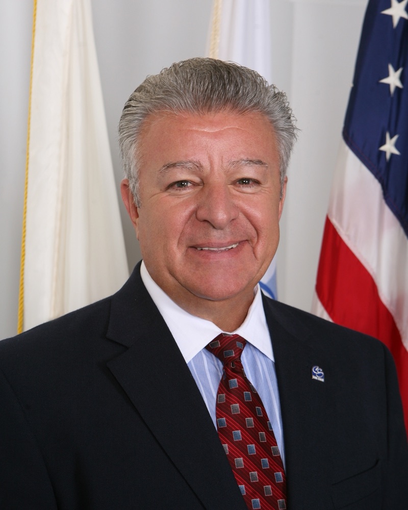 Mayor Frank Saverino Sr. in front of the American and Village of Carol Stream flags